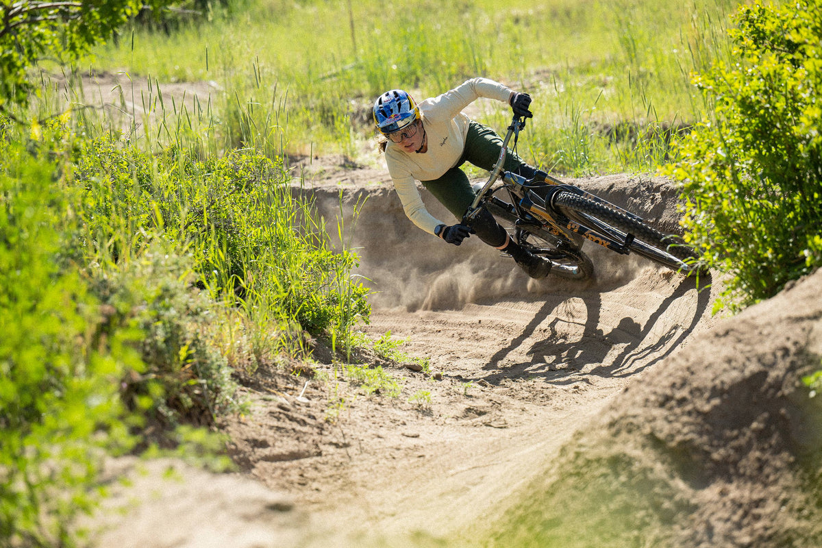 bike rider on a dirt track surrounded by grass and shrubs