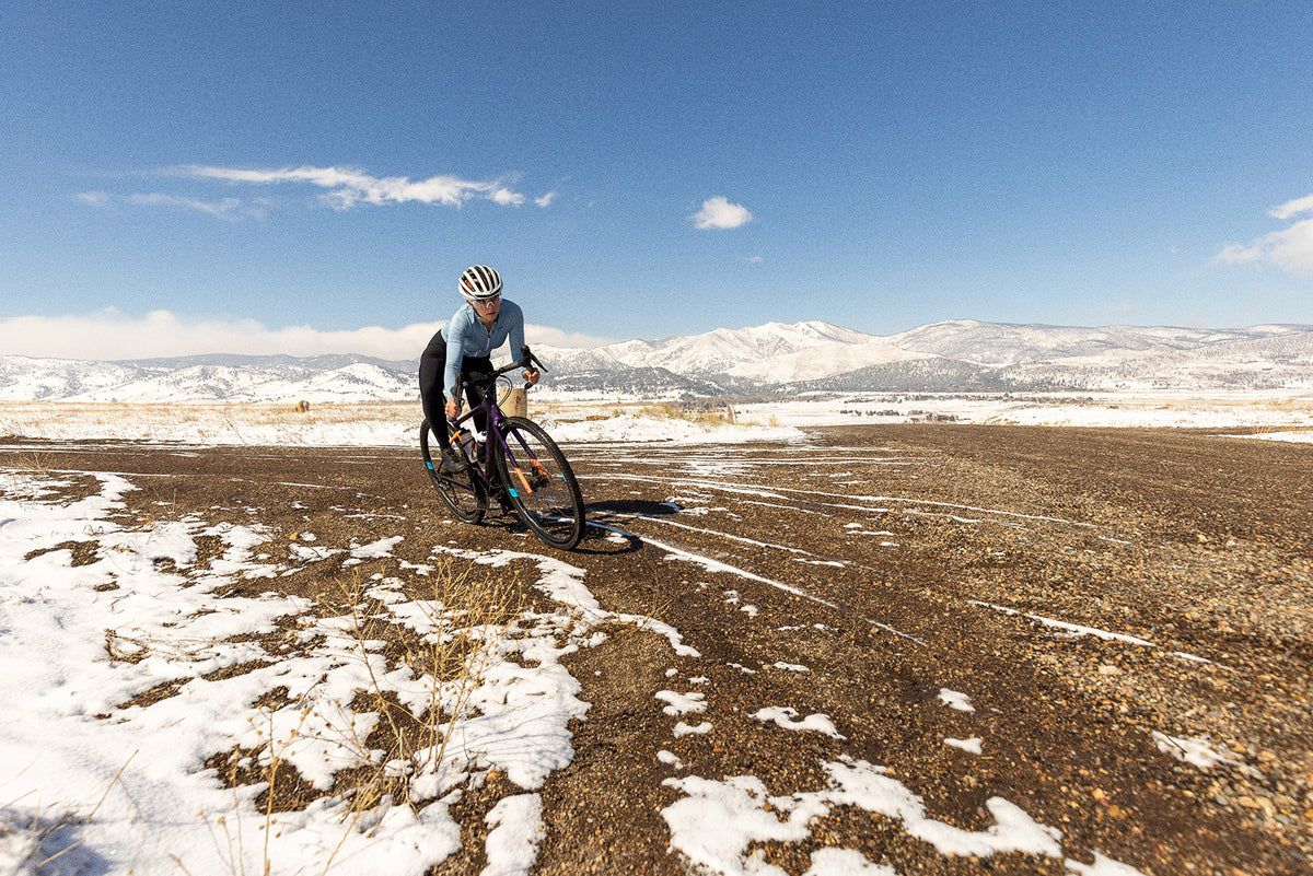 Gravel biker turning carbon gravel wheels on snowy trail