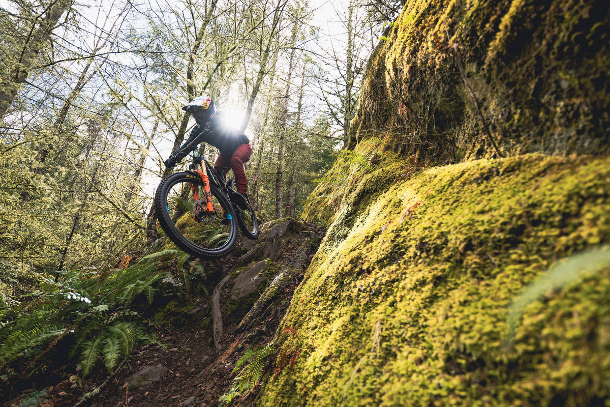 bike rider jumping over rocks on a mountain trail